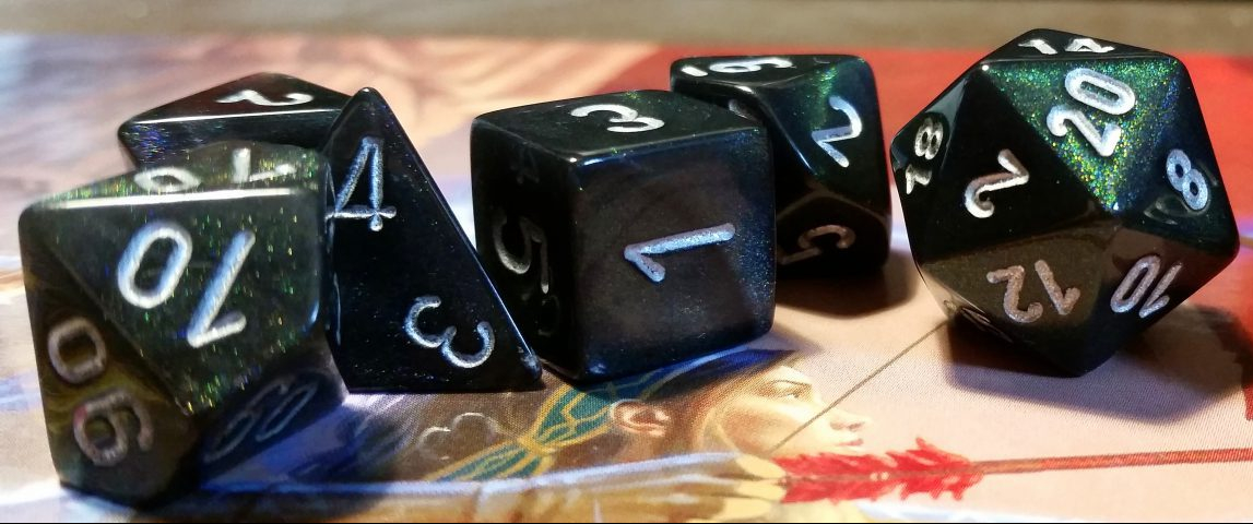 A set of D&D dice on top of a folded DM screen. Image credit: Pixabay.